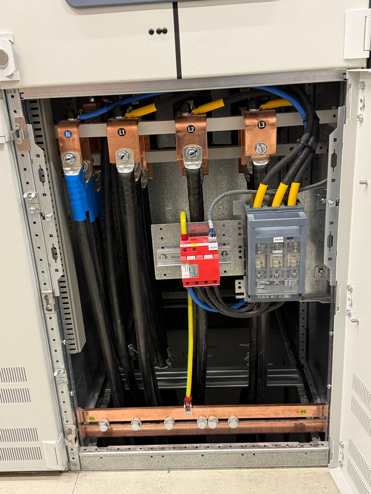 Surge arrester and 125 A fuse switch disconnector below the copper terminals of a main distribution board