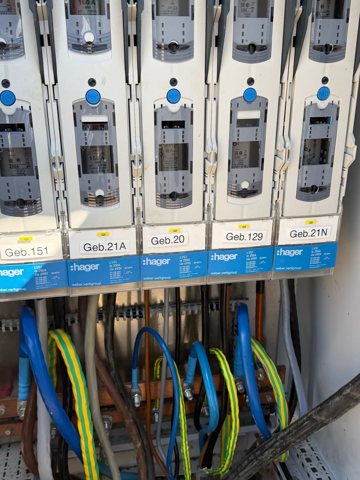 Bina numaralarıyla etiketlenmiş, binalara giden çıkışlara sahip 250 A NH yük ayırıcı dizisi